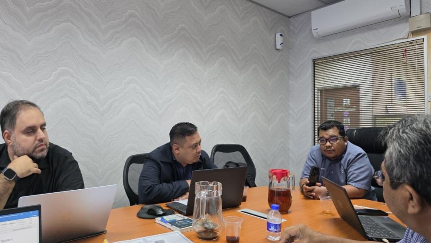 Harvs International consulting session in a Malaysian client boardroom with laptops, documents and briefing materials.